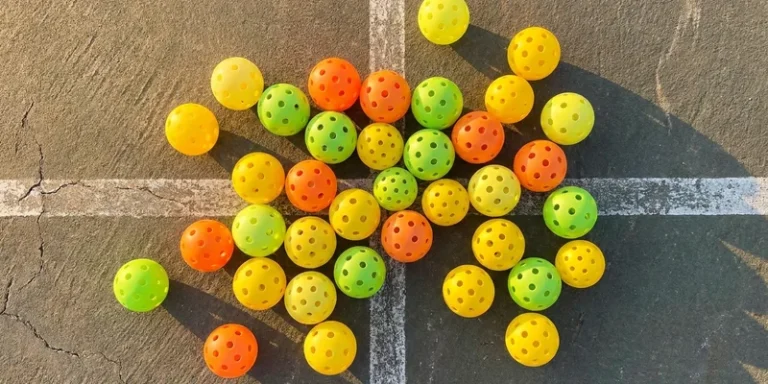 Different colored indoor and outdoor pickleballs compared side by side